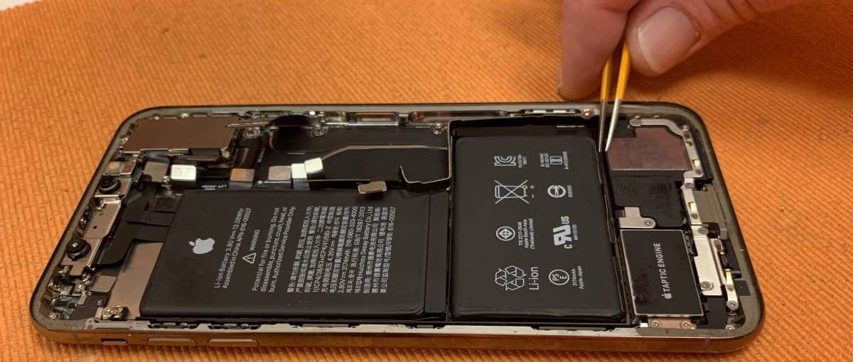 Technician replacing an iPhone battery with precision tweezers